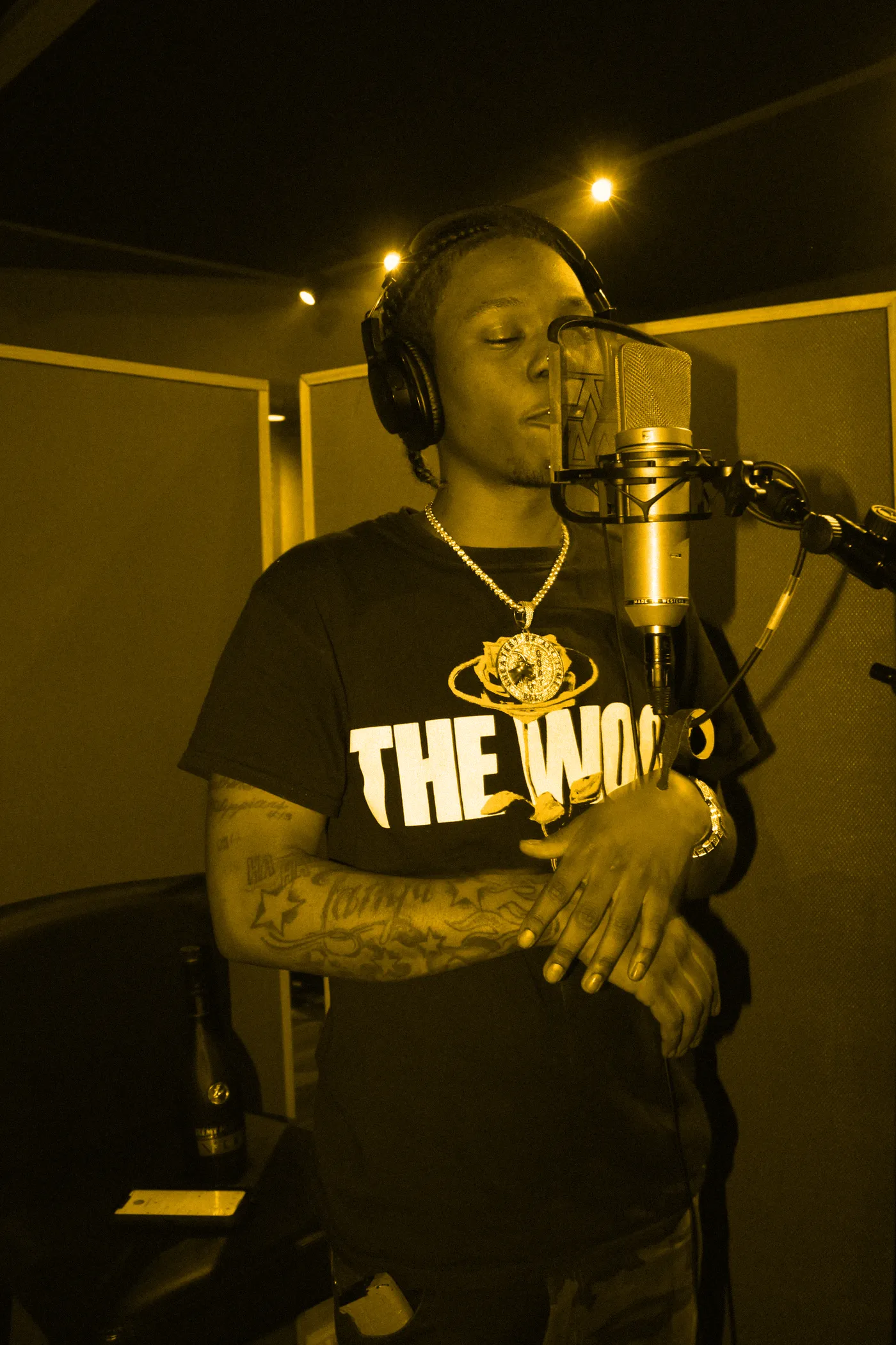 A vocalist recording in the booth, eyes closed